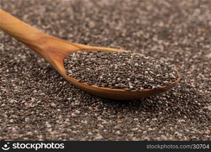 Chia seeds in a wooden spoon on chia background
