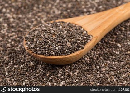 Chia seeds in a wooden spoon on chia background