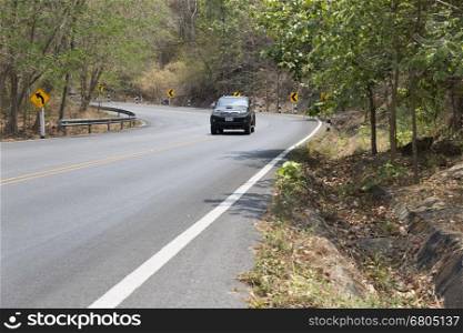 Chiang Mai, Thailand - May 3, 2016: car driving on road on mountain hill in forest in Doi Suthep national park in Chiang Mai, Thailand on May 3, 2016.