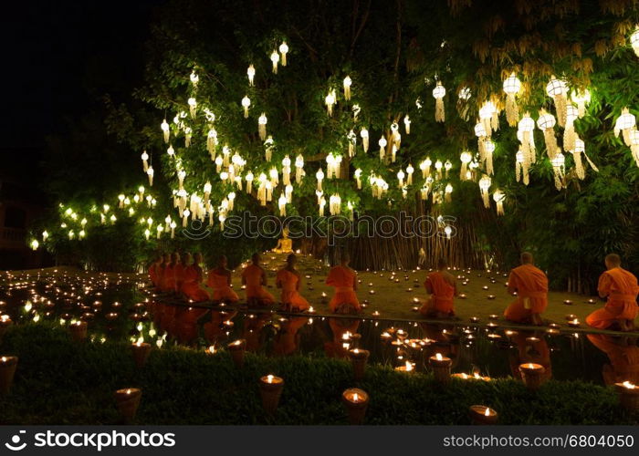 Chiang Mai, Thailand - November 14, 2016: buddhist monk pray at buddha statue in Yeepeng festival at Puntao temple in Chiang Mai, Thailand on November 14, 2016.