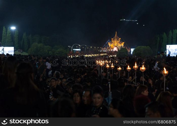 Chiang Mai, Thailand - November 2, 2016: Thai mourners hold candles and pray for the late King Bhumibol Adulyadej at Royal Park Rajapruek, Chiang Mai, Thailand on November 2, 2016.