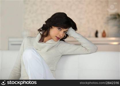 Chic woman sitting on a white sofa