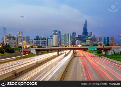 Chicago downtown skyline at twilight with highway and traffic.