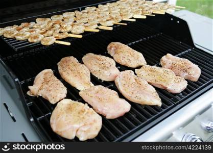 Chicken and shrimp cooking on at backyard barbecue grill.