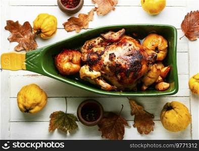 Chicken baked with apples in a baking dish.Autumn recipe. Whole chicken baked with quince
