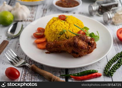 Chicken Biryani in a plate with spices on a white wooden floor