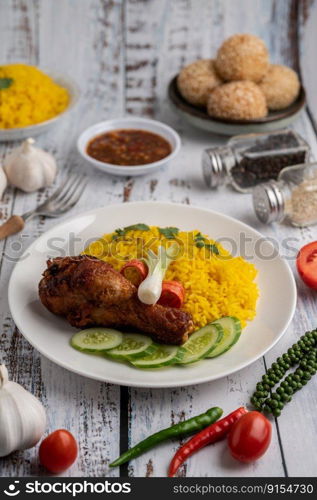 Chicken Biryani in a plate with spices on a white wooden floor