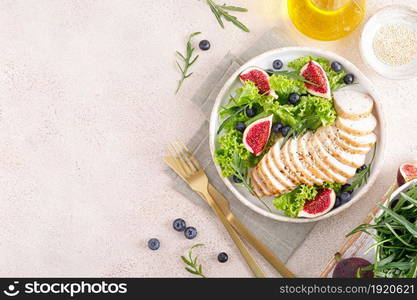 Chicken breast baked and fresh salad of lettuce, arugula, blueberry and figs. Healthy diet food. Top view.