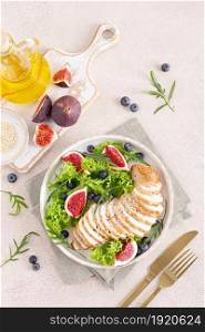 Chicken breast baked and fresh salad of lettuce, arugula, blueberry and figs. Healthy diet food. Top view.