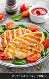 Chicken breast or fillet, poultry meat grilled and fresh vegetable salad of tomato and spinach. Healthy diet menu for lunch