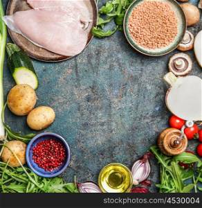 Chicken breast, red lentil, fresh vegetables and various ingredients for cooking on rustic background, top view, frame. Healthy food, diet or clean eating concept