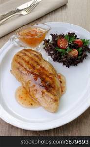 Chicken breast with sweet and sour sauce salad garnish on a plate