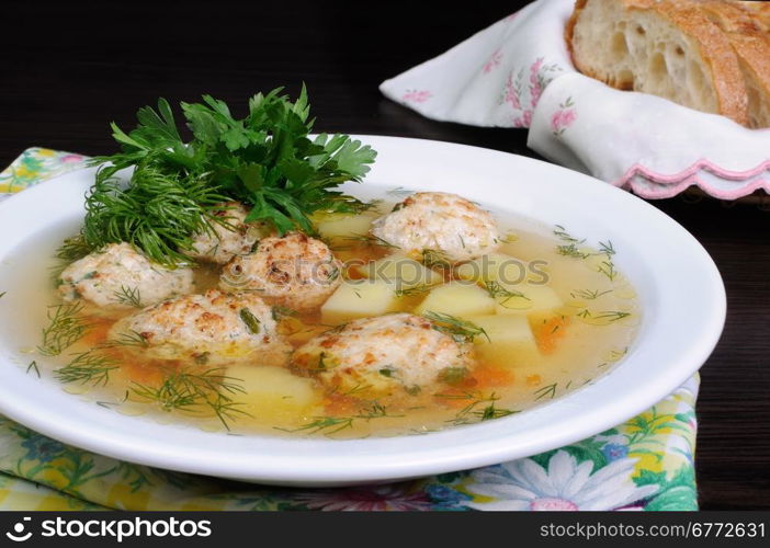 chicken broth of potatoes, carrots and meatballs sprinkled with dill