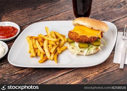 Chicken burger with french fries and ketchup on wooden table