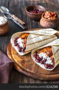 Chicken burritos with ingredients on the wooden board