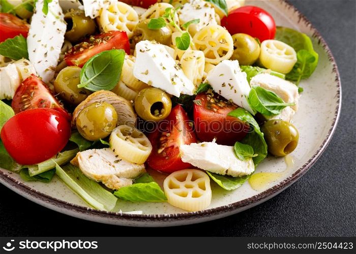 Chicken Caprese pasta salad with mozzarella cheese, olives, tomato and fresh basil