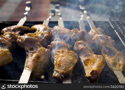 Chicken cooking on barbeque grill with flames