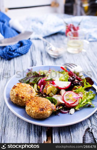 chicken cutlets and greeck salad on plate