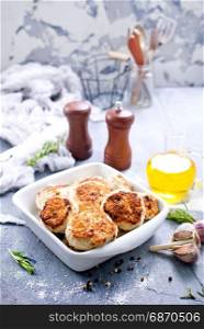 chicken cutlets in white bowl and on a table