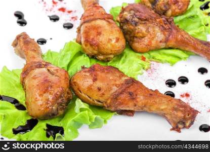 chicken drumstick closeup at white plate with lettuce