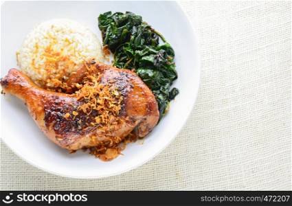 Chicken drumstick marinated with spicy chilli sauce and herbs, served with cooked rice and spinash.