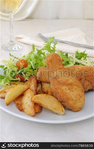Chicken drumsticks in breadcrumbs with chips with salad