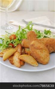 Chicken drumsticks in breadcrumbs with chips with salad