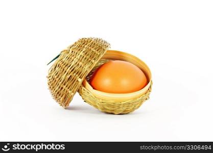Chicken egg in a little basket isolated on white