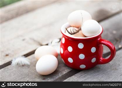 chicken eggs in a big red cup. still life