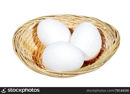 Chicken eggs in a wicker basket on the white background