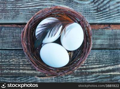 chicken eggs in the nest and on a table