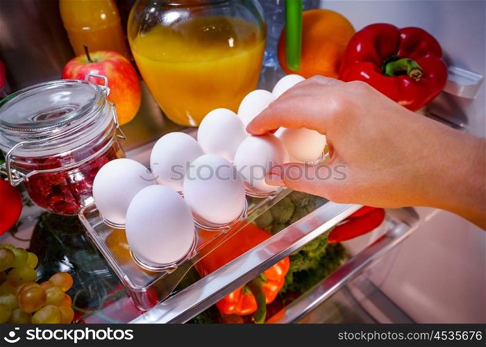 Chicken eggs on a shelf open refrigerator