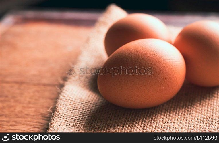 Chicken eggs on sackcloth on wooden table