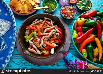 chicken fajitas in a pan with sauces chili and sides Mexican food