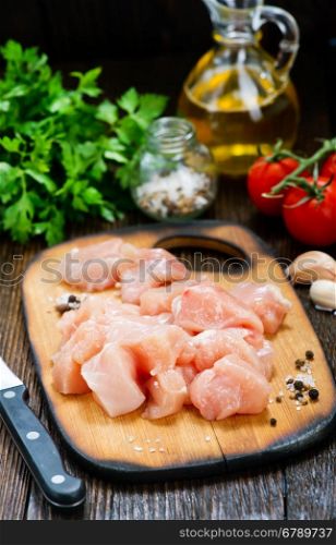 chicken fillet on wooden board and on a table