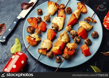 Chicken fillet pieces with mushrooms and pumpkin on wooden skewers.Grilled meat and vegetables. Kebabs with meat,pumpkin and mushrooms