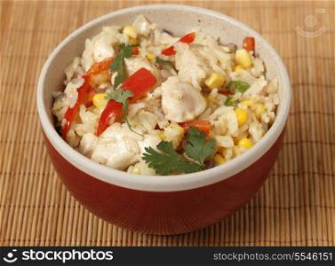 Chicken fried rice, containing capsicum, rice, garlic, egg,ginger and spices, in a bowl