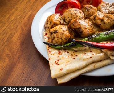 chicken kebabs with flatbread, tomato and pepper