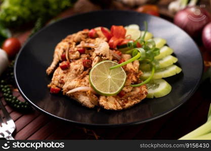 Chicken Larb on the plate With driedχlies, tomatoes, spring onions and≤ttuce.