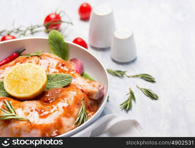 chicken legs with marinade in white dish, close up