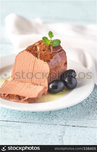 Chicken liver pate with black olives on the white plate: cross section