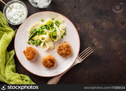 Chicken meat balls with zucchini salad and green peas, with garlic-yogurt sauce
