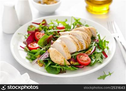 Chicken meat breast and fresh vegetable salad of tomato, onion and salad mix. Healthy and detox food. Ketogenic diet