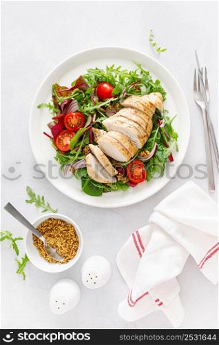 Chicken meat breast and fresh vegetable salad of tomato, onion and salad mix. Healthy and detox food. Ketogenic diet. Top view