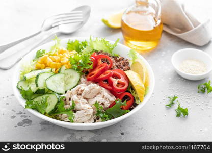 Chicken meat lunch bowl with fresh salad leaves, corn, cucumber, sweet pepper and quinoa