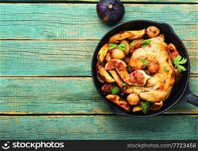 Chicken meat roasted with potatoes and figs.Meat fried with figs in pan.Copy space. Chicken baked with potatoes and figs,space for text