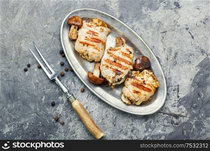 Chicken meat roll.Baked chicken with mushrooms on metal stylish tray. Chicken cutlet with mushrooms.