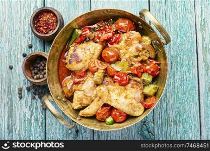 Chicken meat stewed in tomatoes and okra.Appetizing chicken meat grilled barbecue with spices and vegetables. Baked chicken in vegetables