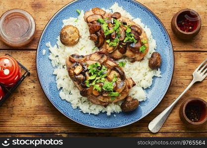 Chicken meat with mushroom sauce on a rice pad. Meat with Sicilian marsala sauce.. Chicken breast with marsala sauce and rice