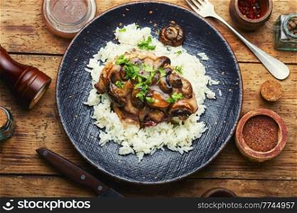 Chicken meat with mushroom sauce on a rice pad. Stewed meat with Italian marsala sauce.. Chicken breast with marsala sauce and rice
